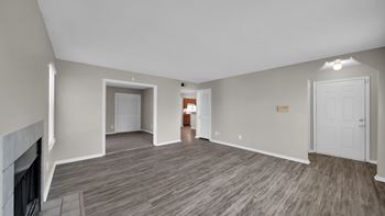 A spacious living room with a fireplace and hardwood flooring.